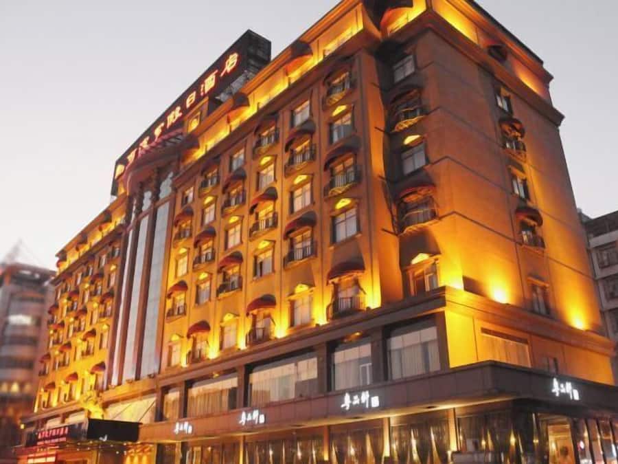 Een meerlaags hotel met een klassiek ontwerp, met balkons en grote ramen.