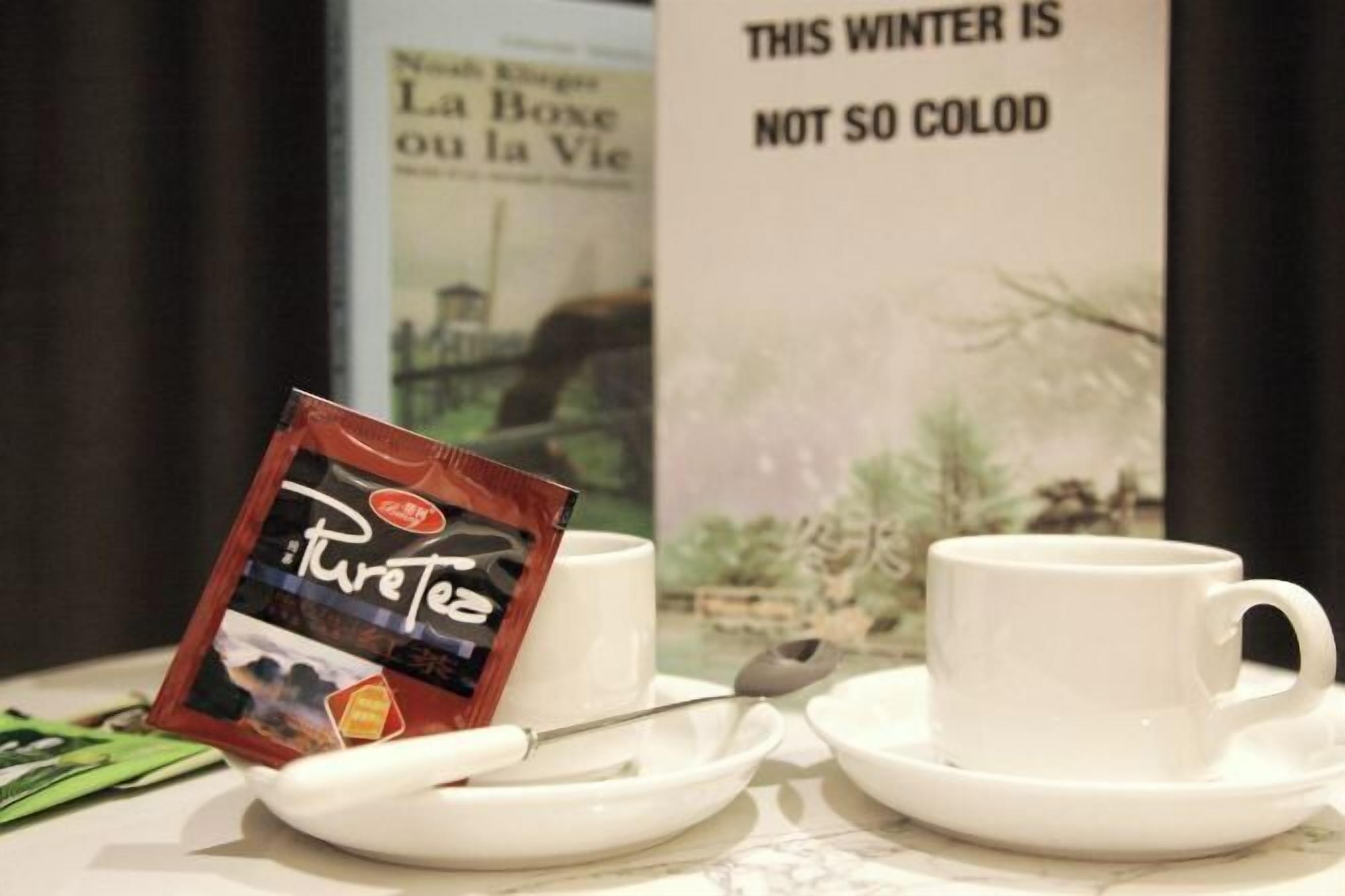 A table with a packet of PureTea, two white cups, and a spoon.