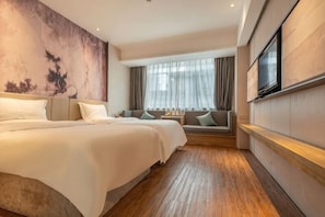 Habitación de hotel con una cama grande, un sofá, un televisor y una ventana con cortinas.