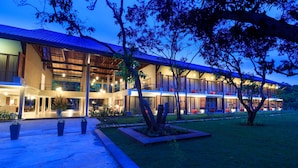 Un hotel moderno con varios pisos, amplias ventanas y fachada bien iluminada.