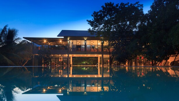 Un edificio moderno con piscina, ventanas amplias y balcón.