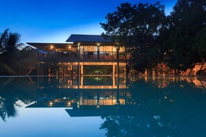 Un bâtiment moderne doté d’une piscine, de grandes fenêtres et d’un balcon.