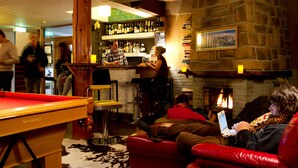 A bar area with a pool table, seating, and a fireplace. - Hakuba House (Hakuba)