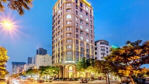 Un hotel de varios pisos con fachada curva, grandes ventanales y una entrada destacada.