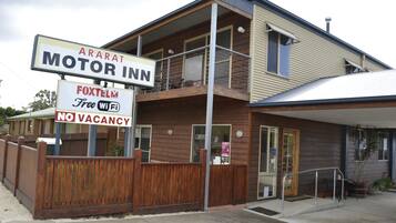 A two-story building with a sign for 'Motor Inn' and 'Foxtelex Free Wi-Fi'.