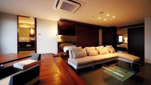A modern living room with a sofa, a glass coffee table, and a wooden dining table.