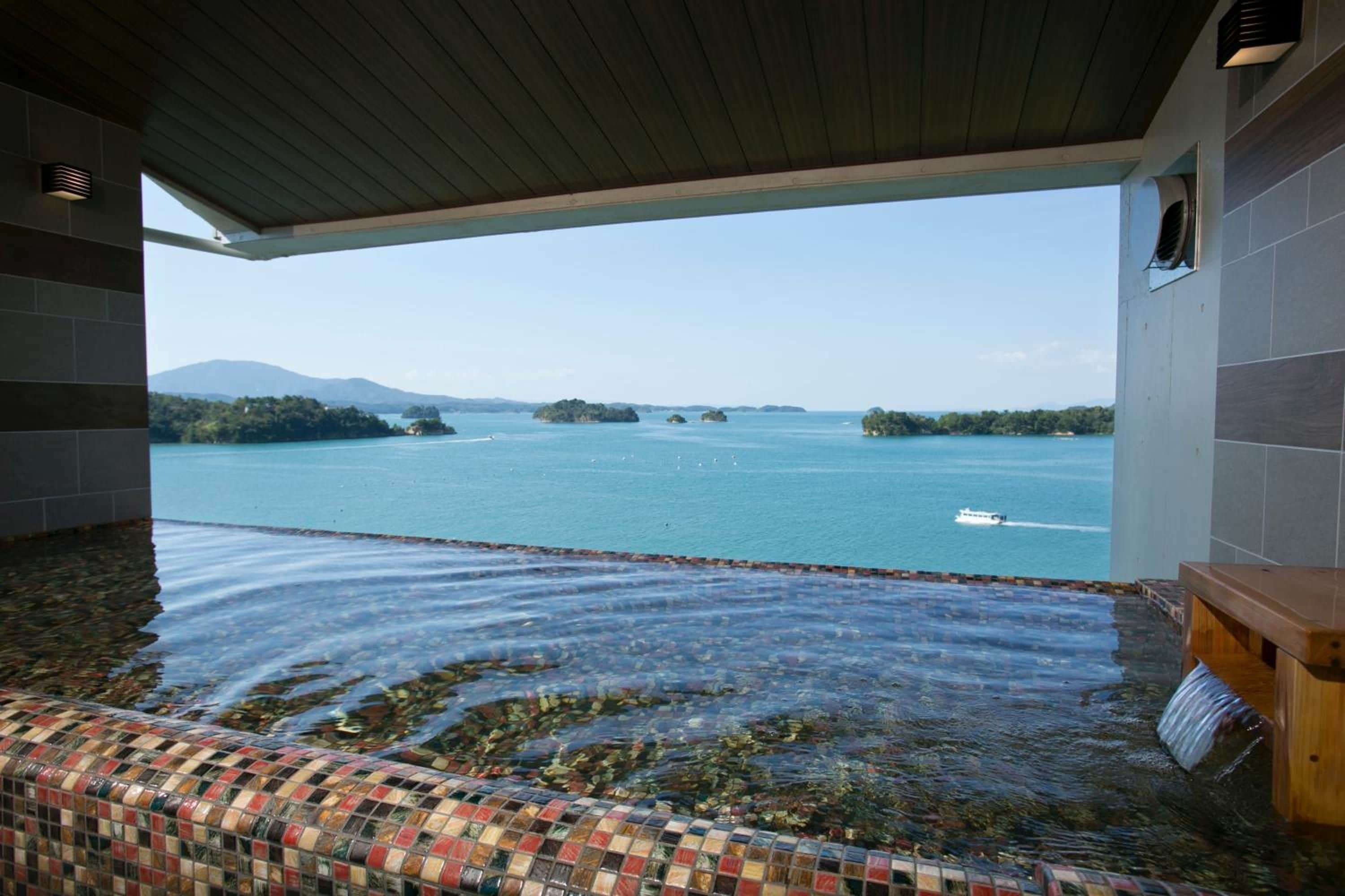 A hot tub with a view of a calm lake and boats.