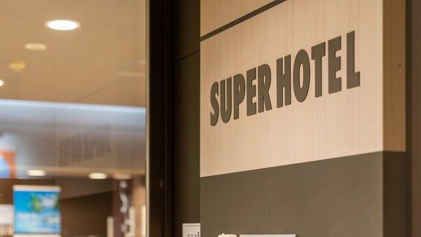 A sign reading "SUPERHOTEL" on a wall, indicating the name of the establishment. - Super Hotel Fuji Inter (Fuji)