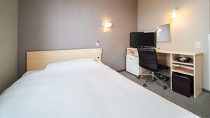A hotel room with a bed, a desk with a computer, a chair, a TV, and a small storage unit. - Super Hotel Fuji Inter (Fuji)