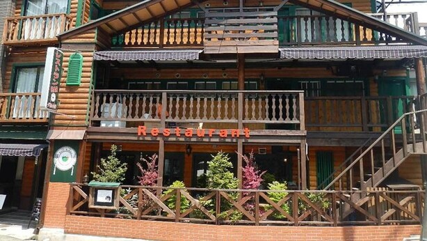 A two-story wooden building with a balcony and a sign that reads 'Restaurant'. - Hotel Morgenrot (Kobe)