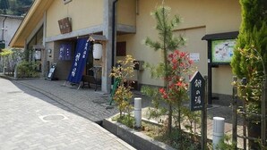 A building with a tiled roof, a small entrance, and a signboard. - Hotel Morgenrot (Kobe)