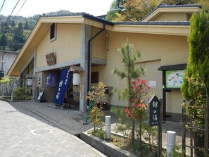 A building with a tiled roof, a small entrance, and a signboard. - Hotel Morgenrot (Kobe)