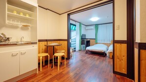 A compact room with a kitchenette, a small dining area, and a bed. - Hotel Morgenrot (Kobe)