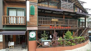 Un edificio de madera de dos plantas con un restaurante en la planta baja.