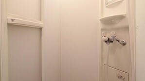 A white bathroom with a shower, a toilet, and a sink. - Hotel Morgenrot (Kobe)