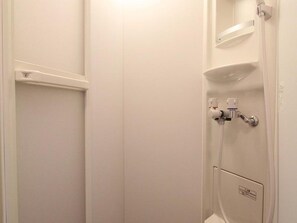 A white bathroom with a shower, a toilet, and a sink. - Hotel Morgenrot (Kobe)