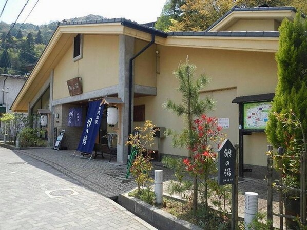 Un edificio con techo de tejas, una entrada pequeña y un letrero con caracteres japoneses.