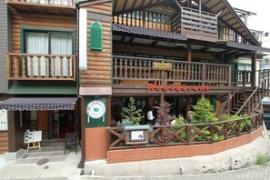 A restaurant with a wooden facade, outdoor seating, and a sign indicating it's a Grill Restaurant. - Hotel Morgenrot (Kobe)