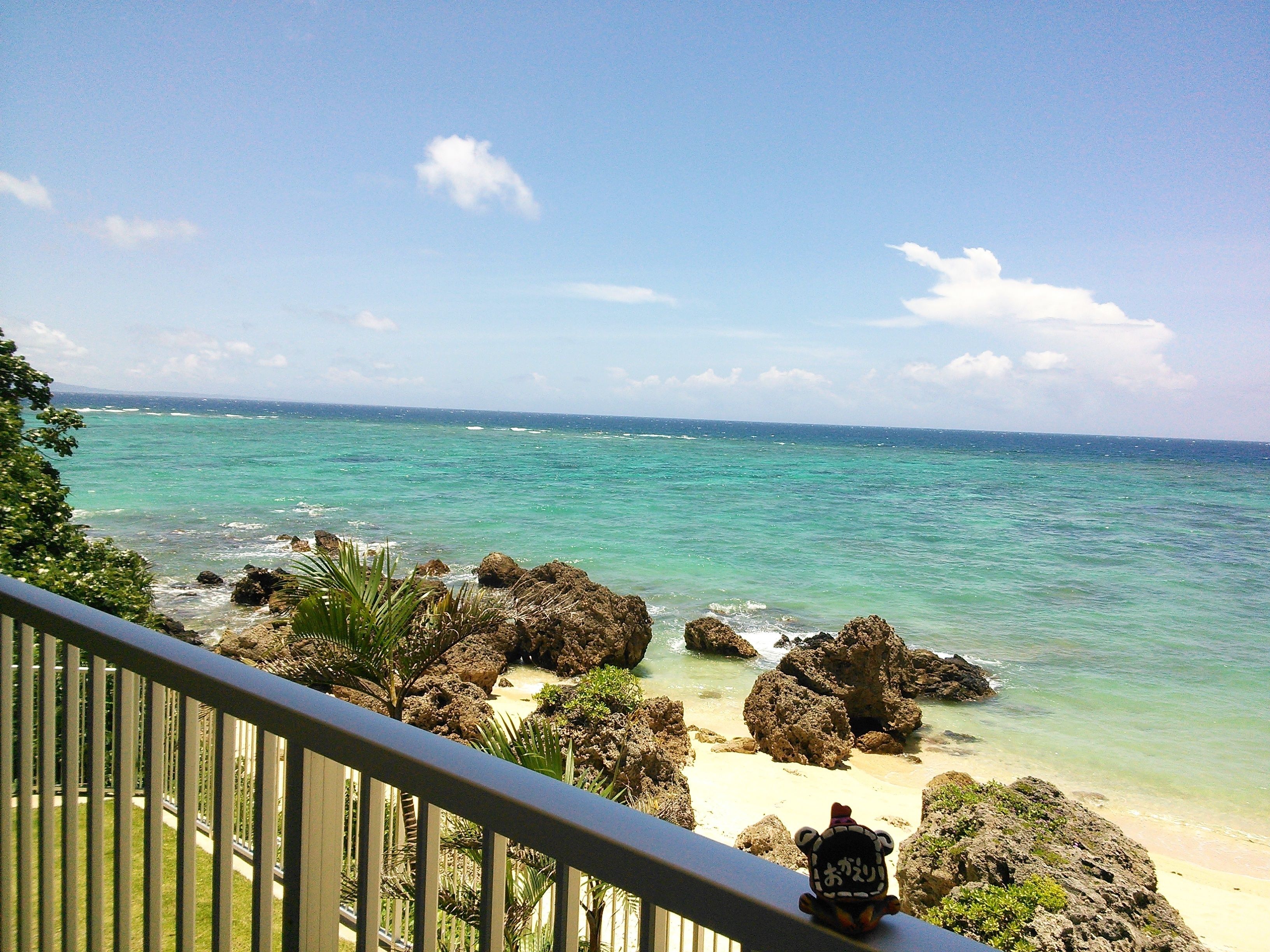 A balcony with a view of a beach and ocean.