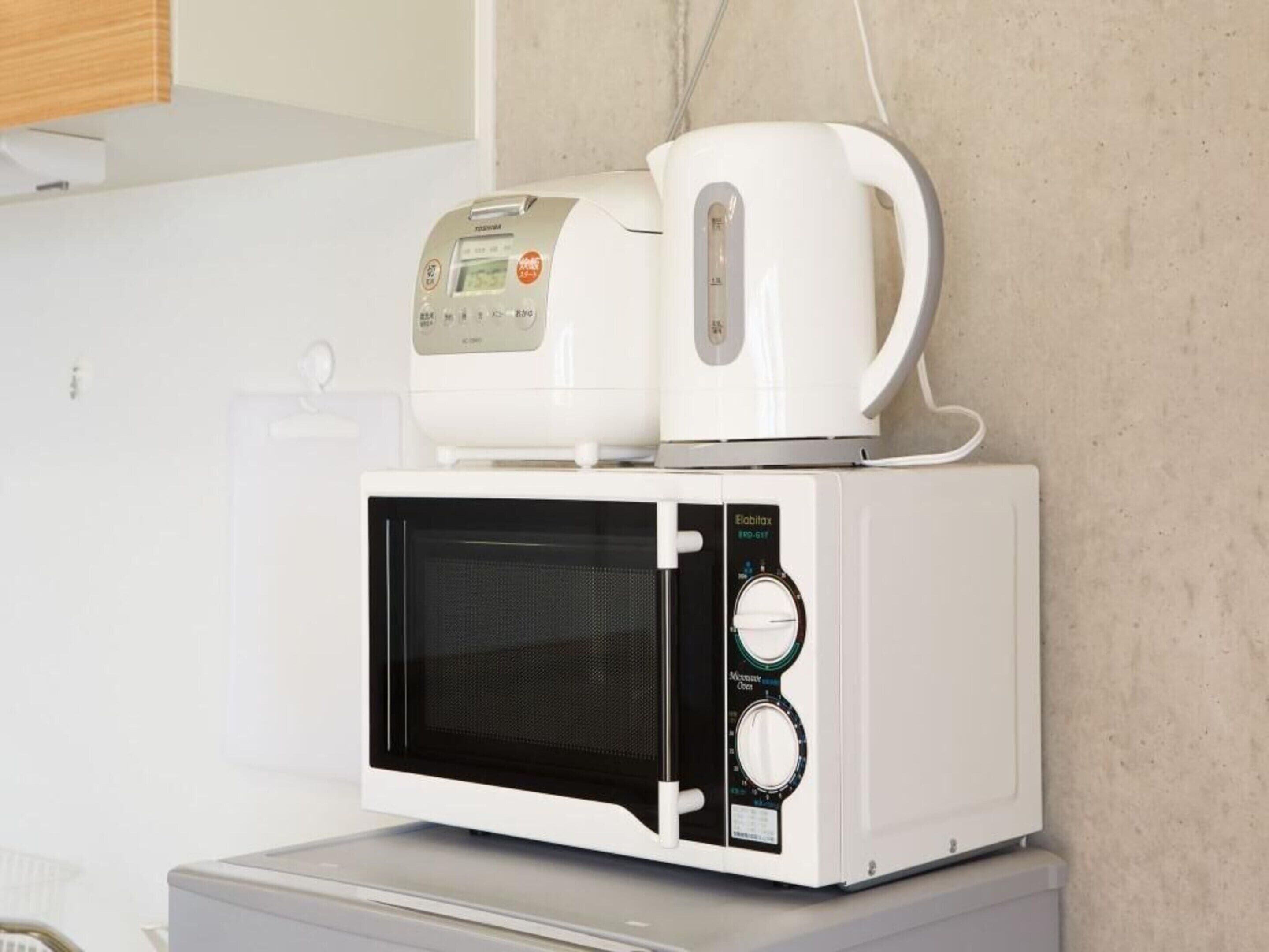 Um micro-ondas compacto com visor digital e cafeteira por cima.
