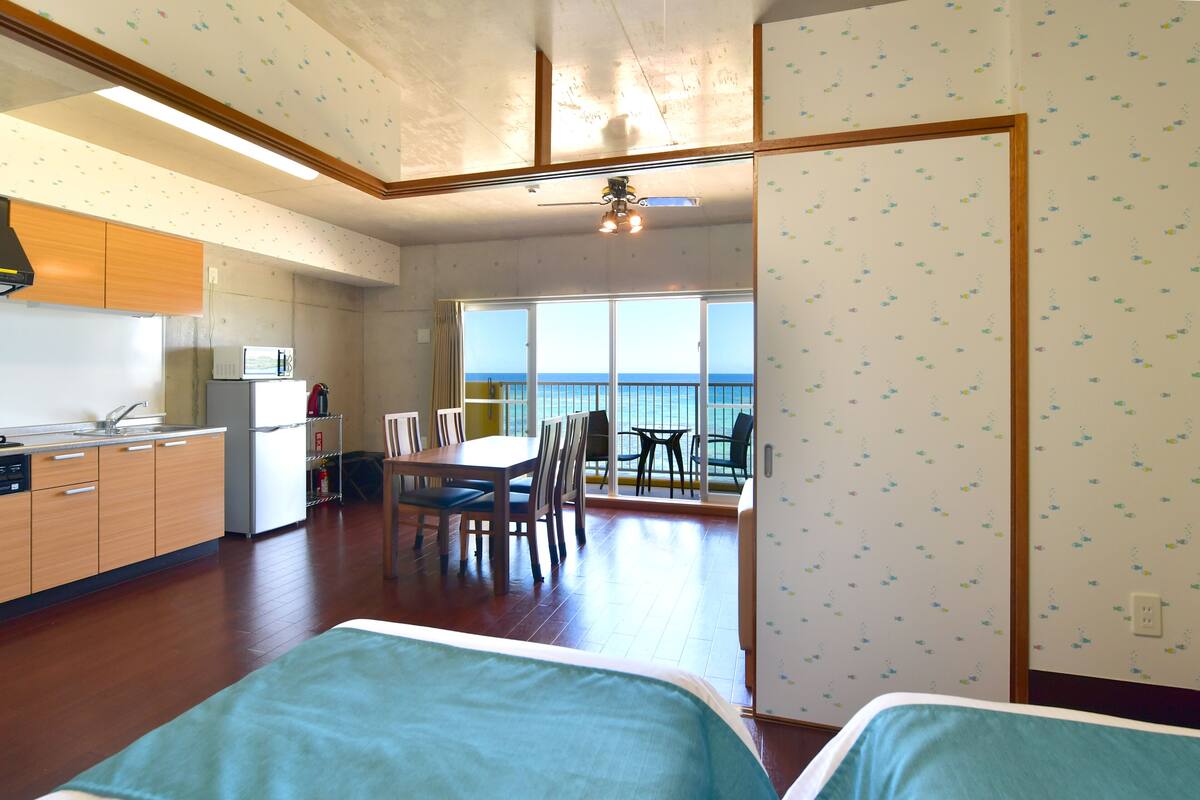 Una habitación con kitchenette, zona de comedor y balcón con vistas.