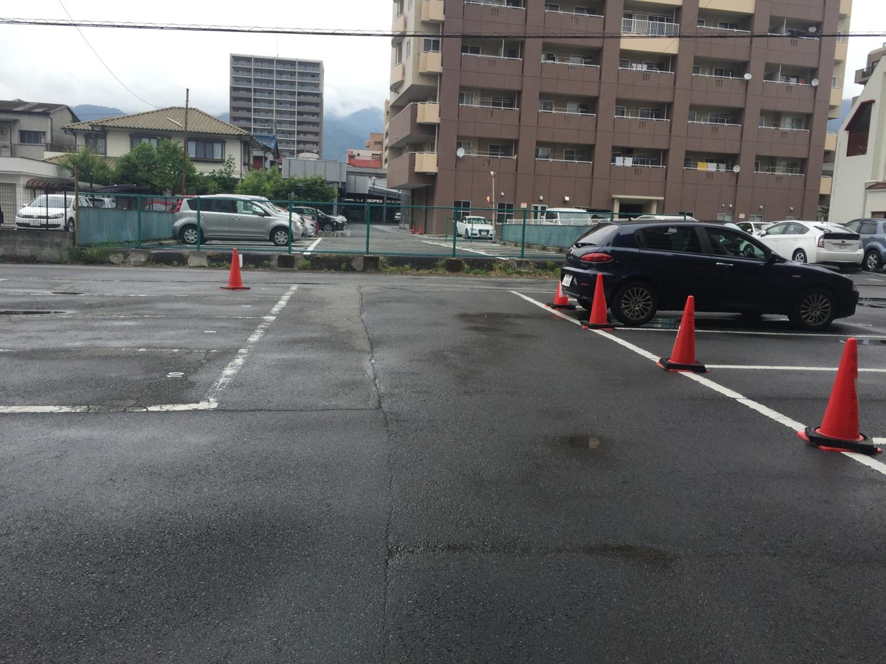 A parking lot with multiple cars and orange traffic cones.