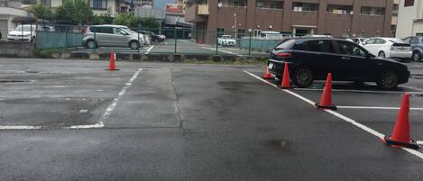 A parking lot with multiple cars and orange traffic cones.