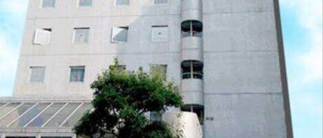 Un edificio alto con un letrero que dice "Hotel" y "Club" en inglés y japonés.