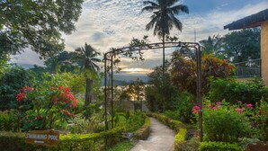 A pathway leading to a wooden archway with a sign indicating a swimming pool. - Oruthota Chalets (Maberiyatenna)