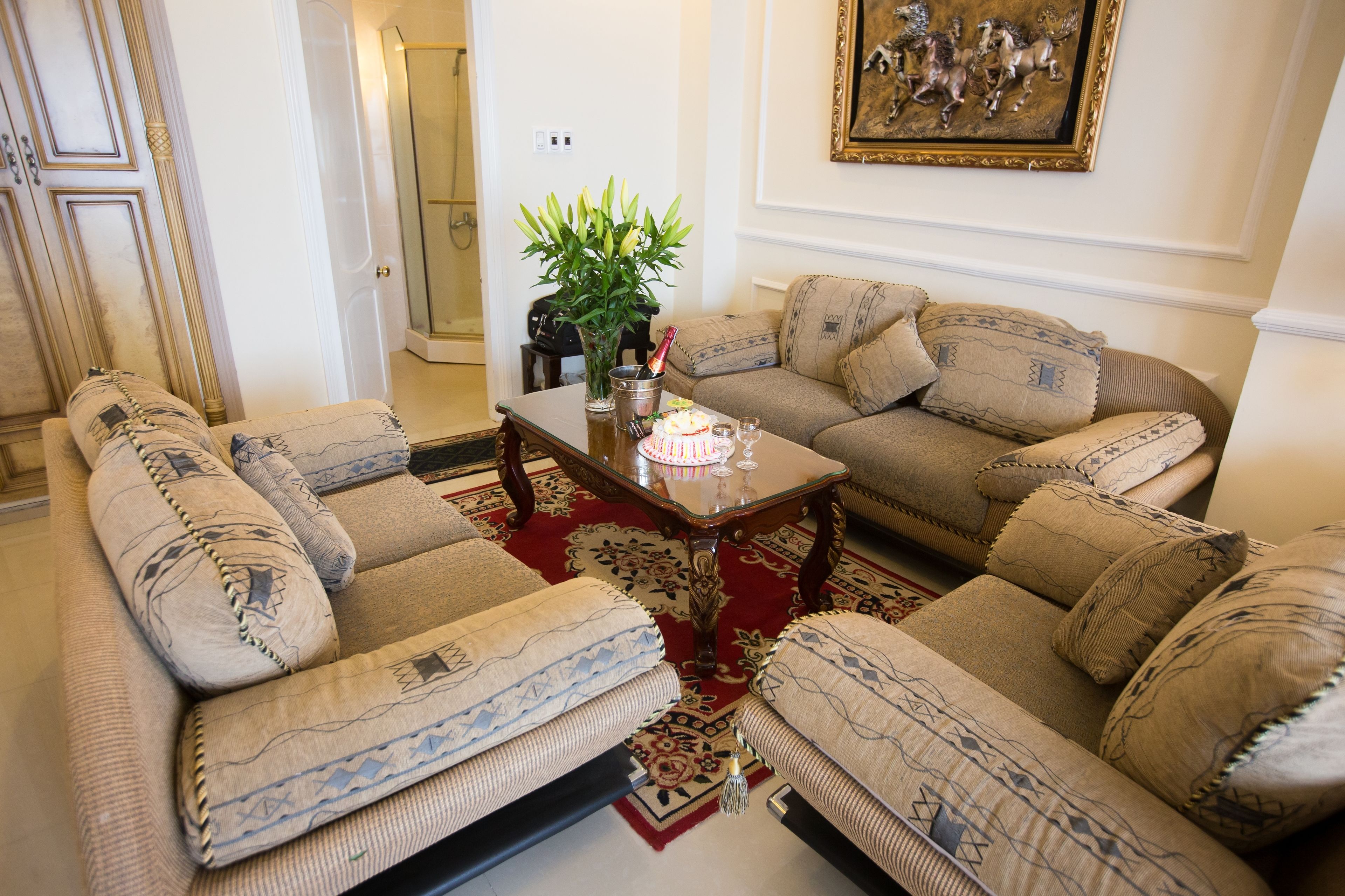 A living room with two sofas, a coffee table, and a potted plant.