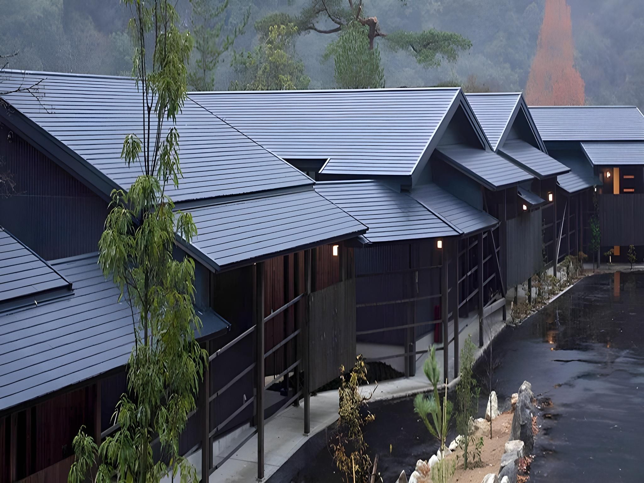 A row of traditional-style buildings with dark roofs and wooden exteriors, likely part of a hotel or resort.