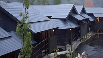A row of traditional-style buildings with dark roofs and wooden exteriors, likely part of a hotel or resort.