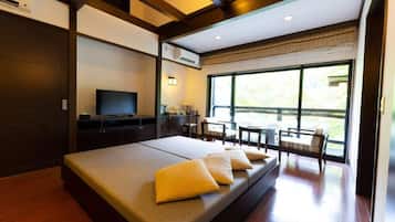 Habitación de hotel moderna con una cama grande, televisor, escritorio y vistas al exterior.