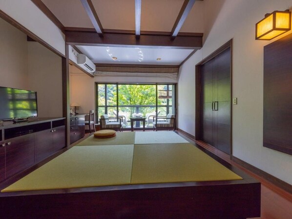 A room with tatami mats, a television, a dining area with chairs, and a view through large windows. - Takedao Onsen Koyokan Bettei Azale (Takarazuka)