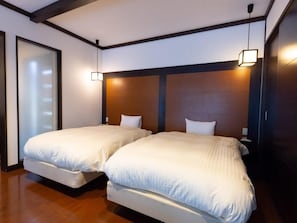 A hotel room with two beds, wooden headboards, and a sliding glass door. - Takedao Onsen Koyokan Bettei Azale (Takarazuka)