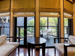 Un espace extérieur aménagé, abrité et doté d’une table et de chaises, de grandes fenêtres et d’une vue sur l’extérieur.
