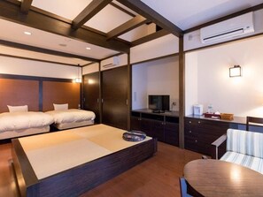 Une chambre d’hôtel équipée d’un lit, d’un bureau, d’une chaise, d’une télévision et d’un appareil de climatisation.