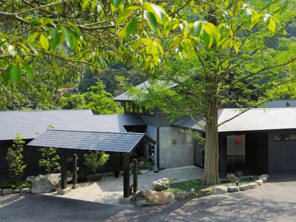 A modern building with a covered entrance and a tree in front.