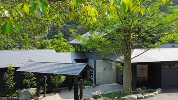 A modern building with a covered entrance and a tree in front.