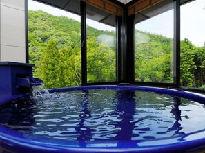 A hot tub with a view of a forested hillside. - Takedao Onsen Koyokan Bettei Azale (Takarazuka)