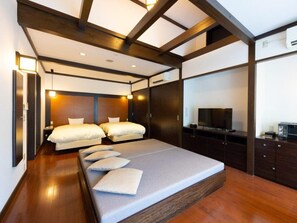 A modern bedroom with a large bed, bedside tables, a flat-screen TV, and built-in cabinets. - Takedao Onsen Koyokan Bettei Azale (Takarazuka)