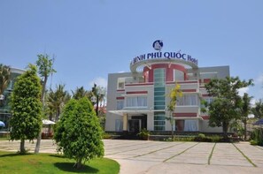A hotel with a modern design, featuring a prominent logo at the top.