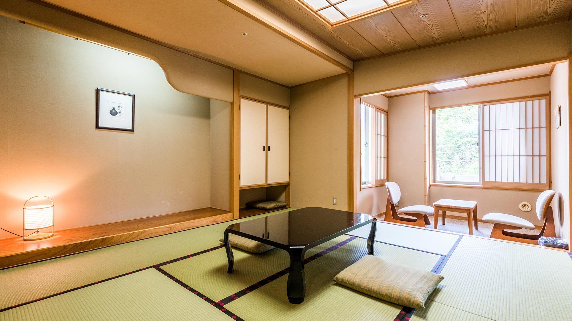 Une pièce de style japonais traditionnel, avec un sol recouvert de tatamis, une table basse et des portes coulissantes.