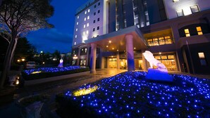 Entrada de hotel con luces azules iluminadas y una estatua.