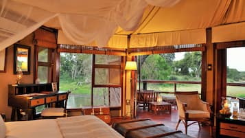 Una habitación con cama, escritorio, silla y vistas al exterior.
