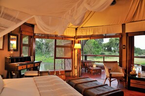 A room with a bed, a desk, a chair, and a view of the outdoors. - Hamiltons Tented Camp (KRUGER NATIONAL PARK)