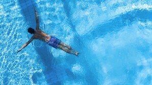 Una persona nadando en una piscina.