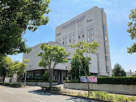 Un edificio de hotel de varios pisos con fachada plana, varias ventanas y un cartel que indica que es un hotel.