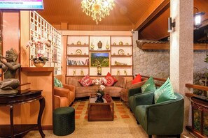 A cozy living room with a sofa set, a coffee table, and decorative items. - Vimonsiri Hill Resort & Spa (Chalong)