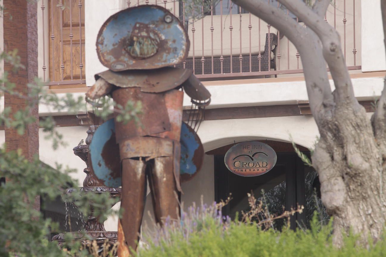 A vintage metal sculpture in front of a building with a sign that reads "The Inn at Croad Vineyards."